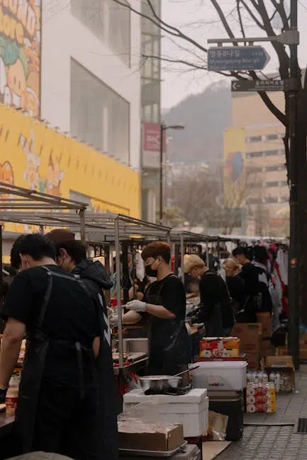 Street food market with busy vendors wearing masks.