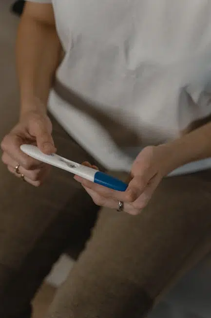 Person examining a pregnancy test result indoors.