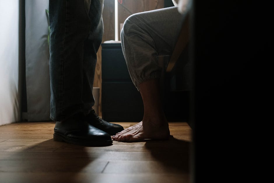 Shoes and bare feet on wooden floor.